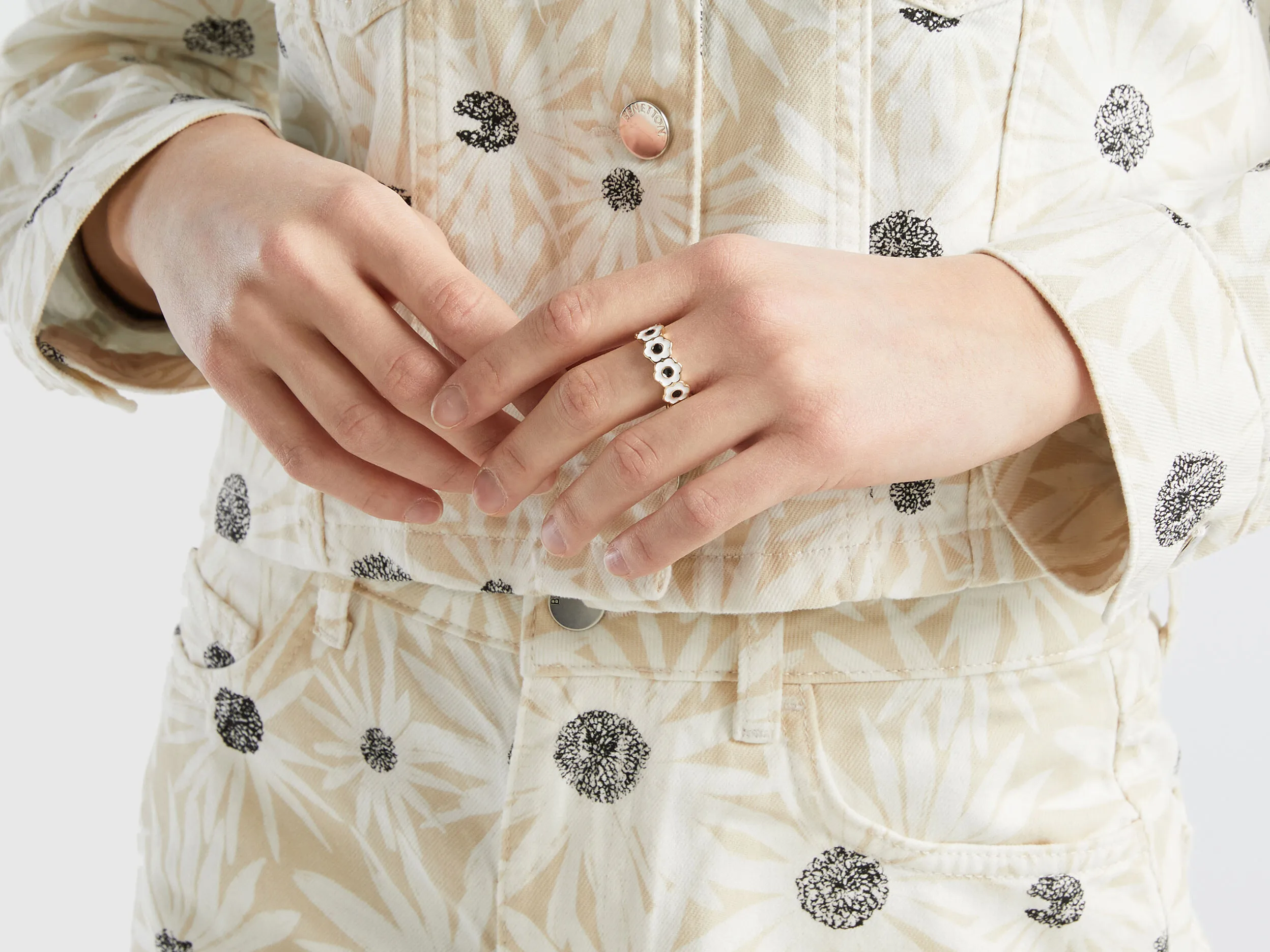 Anillo dorado con flores blancas